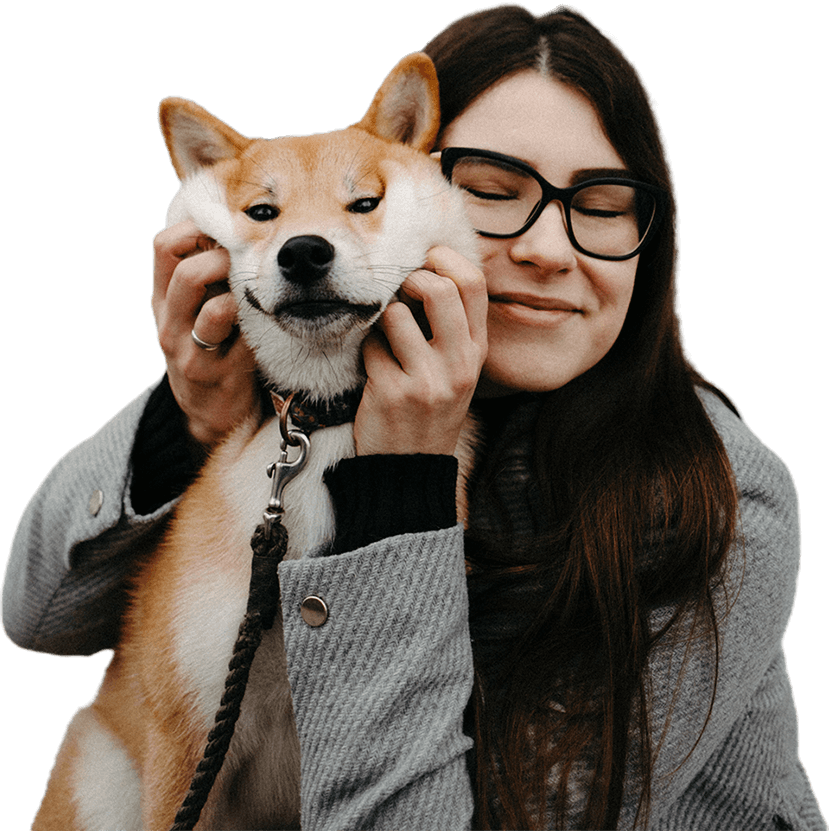 A woman holding her dog on a leash.