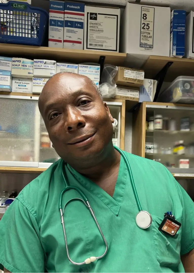 A male doctor in green scrubs and a stethoscope.